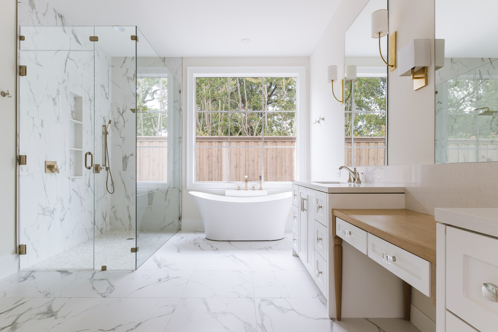 This is an example of a mid-sized transitional master bathroom in Dallas with shaker cabinets, white cabinets, a freestanding tub, a curbless shower, white tile, porcelain tile, white walls, porcelain floors, an undermount sink, engineered quartz benchtops, white floor, a hinged shower door and beige benchtops.