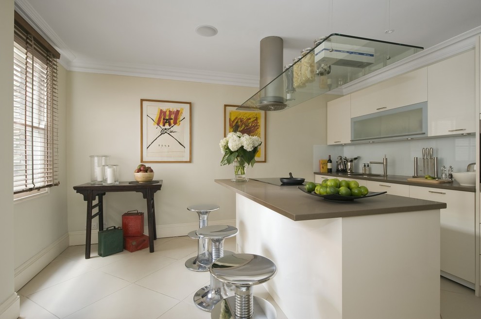 Contemporary galley kitchen in London with flat-panel cabinets and white cabinets.