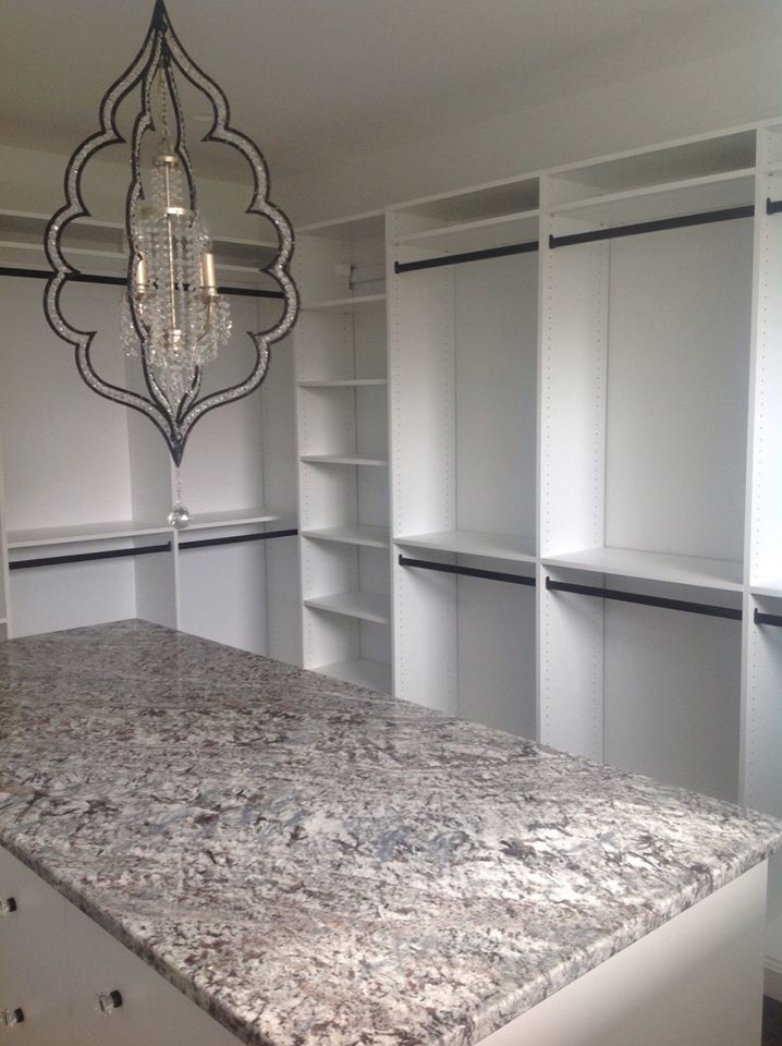 This is an example of a large transitional women's dressing room in Chicago with white cabinets, flat-panel cabinets and carpet.