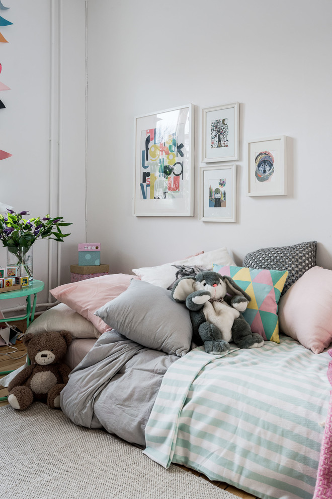 Inspiration for a scandinavian gender-neutral kids' bedroom for kids 4-10 years old in Gothenburg with white walls and medium hardwood floors.