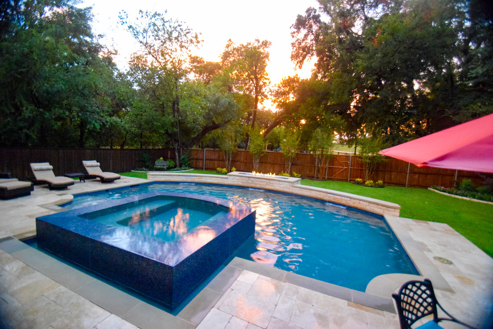 Inspiration for a mid-sized traditional backyard custom-shaped infinity pool in Dallas with a water feature and natural stone pavers.