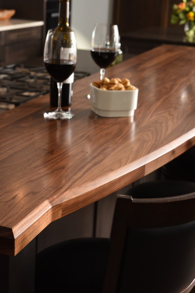 Example of a transitional galley medium tone wood floor kitchen design in Seattle with shaker cabinets, dark wood cabinets, wood countertops and two islands