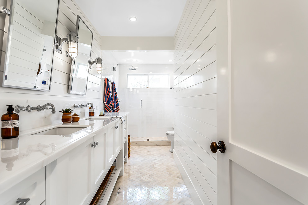Photo of a mid-sized contemporary master wet room bathroom in Los Angeles with shaker cabinets, white cabinets, a one-piece toilet, white tile, ceramic tile, white walls, mosaic tile floors, an undermount sink, engineered quartz benchtops, a hinged shower door and white benchtops.