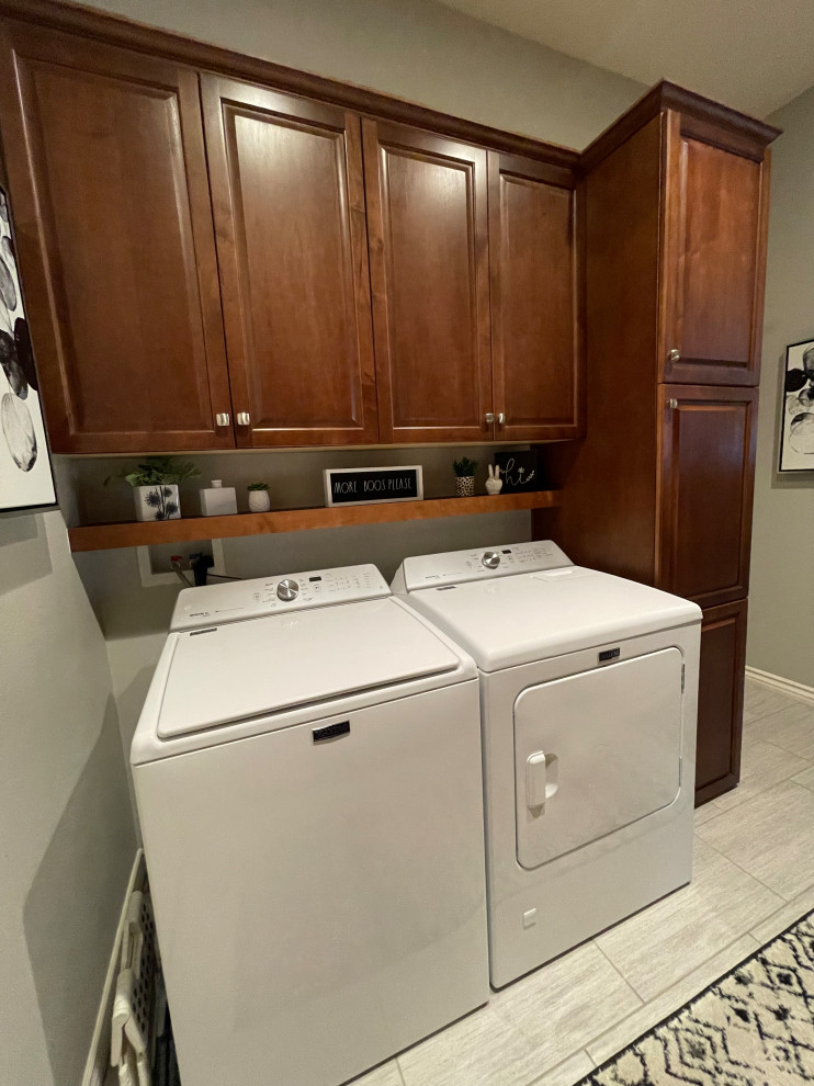 Inspiration for a mid-sized transitional u-shaped travertine floor and brown floor dedicated laundry room remodel with raised-panel cabinets, brown cabinets, gray walls and a side-by-side washer/dryer