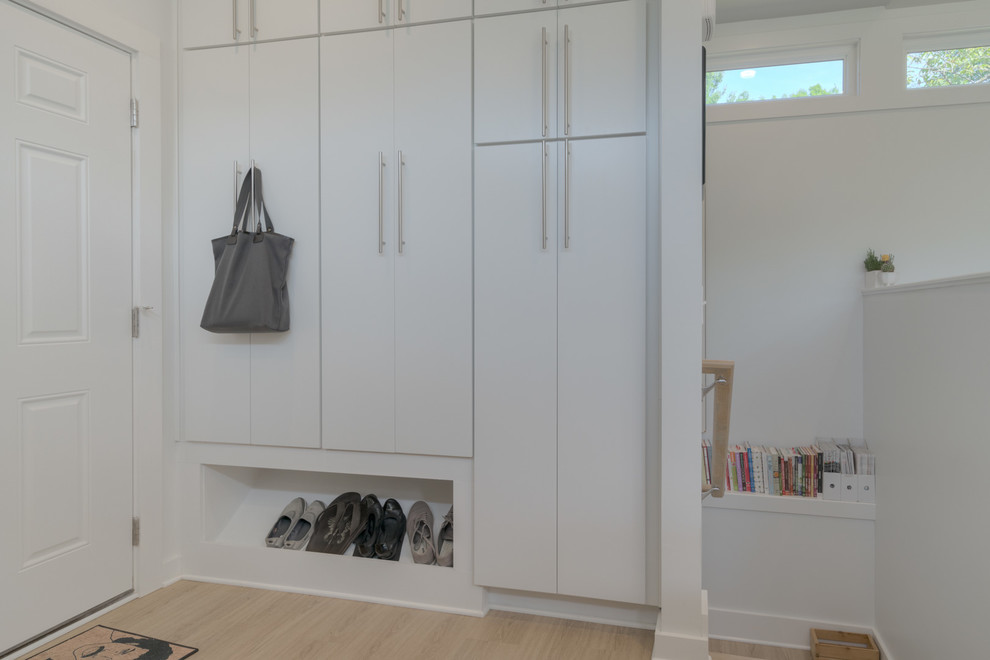 Inspiration for a small modern l-shaped vinyl floor and beige floor open concept kitchen remodel with an undermount sink, flat-panel cabinets, white cabinets, quartz countertops, gray backsplash, marble backsplash and stainless steel appliances
