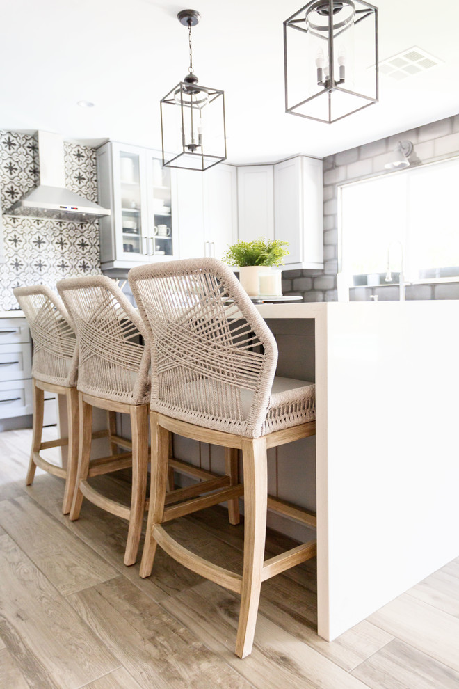 Mid-sized transitional u-shaped light wood floor and gray floor eat-in kitchen photo in Phoenix with an undermount sink, recessed-panel cabinets, gray cabinets, quartz countertops, multicolored backsplash, ceramic backsplash, stainless steel appliances, an island and white countertops