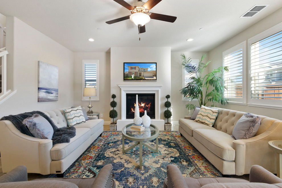 Design ideas for a large transitional enclosed living room in Sacramento with beige walls, a standard fireplace, a plaster fireplace surround, a wall-mounted tv and beige floor.