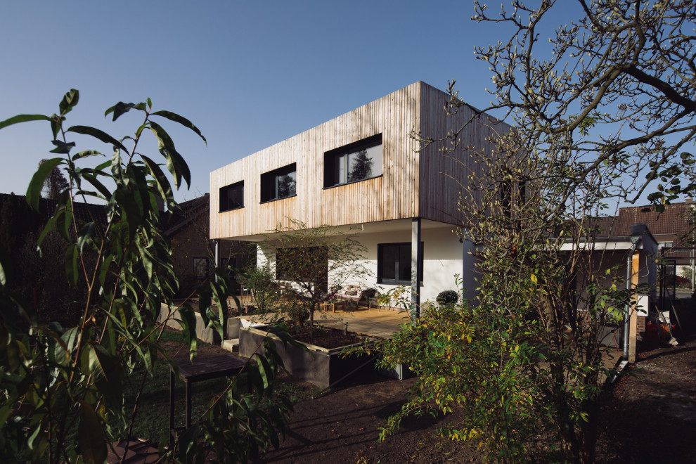 Inspiration pour une façade de maison minimaliste en bardage à clin de taille moyenne et à un étage avec un revêtement mixte, un toit en appentis, un toit en tuile et un toit gris.