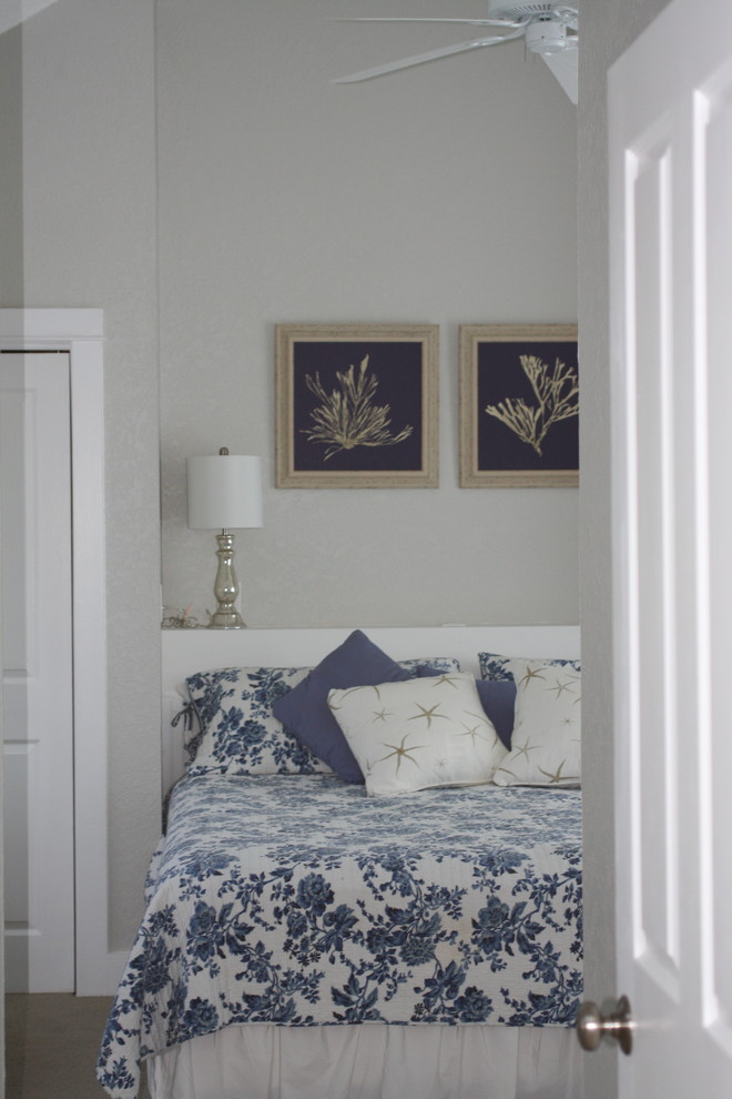 Inspiration for a beach style guest bedroom in Other with beige walls and carpet.