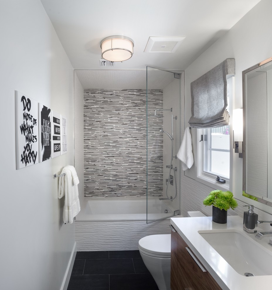 This is an example of a mid-sized contemporary 3/4 bathroom in Los Angeles with flat-panel cabinets, dark wood cabinets, an alcove tub, a shower/bathtub combo, black tile, gray tile, white tile, glass tile, white walls, porcelain floors, an undermount sink, engineered quartz benchtops, black floor, a hinged shower door and white benchtops.