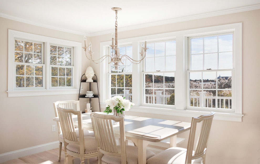 This is an example of a beach style dining room in Boston with beige walls and medium hardwood floors.