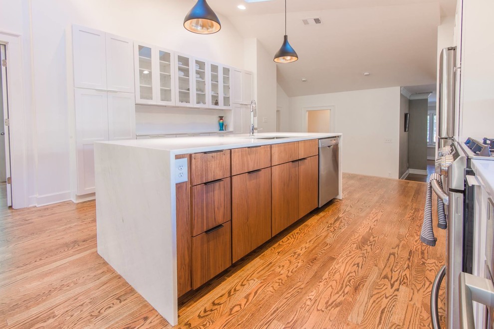 Example of a mid-sized transitional single-wall light wood floor open concept kitchen design in Atlanta with a double-bowl sink, recessed-panel cabinets, white cabinets, marble countertops, white backsplash, subway tile backsplash, stainless steel appliances and an island