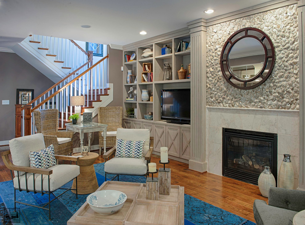Inspiration for a mid-sized beach style open concept living room in DC Metro with grey walls, medium hardwood floors, a standard fireplace, a stone fireplace surround, a freestanding tv and brown floor.