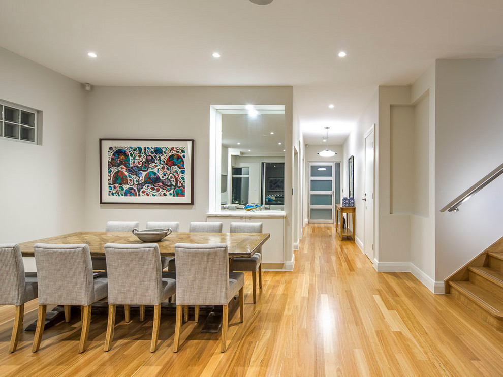 This is an example of a contemporary dining room in Adelaide with beige walls, medium hardwood floors and beige floor.