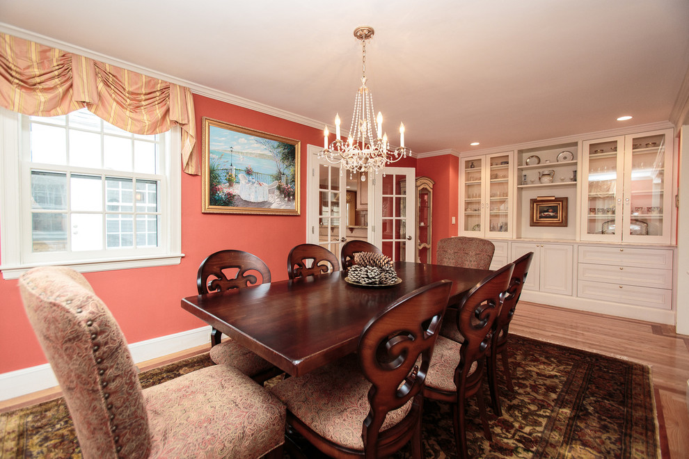 Design ideas for a traditional separate dining room in Boston with red walls and light hardwood floors.