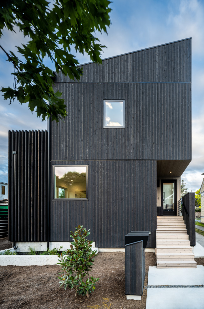Источник вдохновения для домашнего уюта: четырехэтажный, деревянный, черный частный загородный дом в стиле модернизм с двускатной крышей, крышей из смешанных материалов и черной крышей
