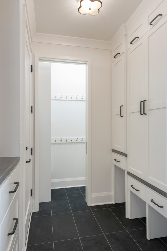 Design ideas for a small transitional gender-neutral walk-in wardrobe in Minneapolis with shaker cabinets, white cabinets, slate floors and grey floor.