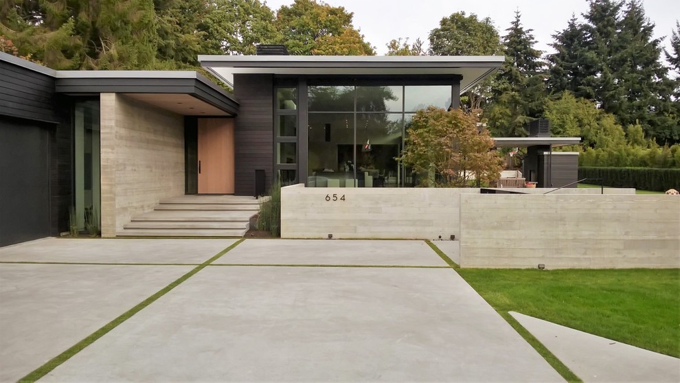 Design ideas for a modern one-storey black exterior in Seattle with wood siding and a flat roof.