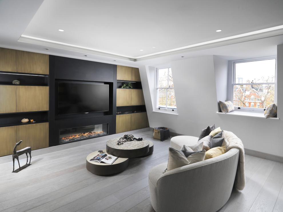 Design ideas for a contemporary open concept living room in London with white walls, light hardwood floors, a ribbon fireplace and grey floor.
