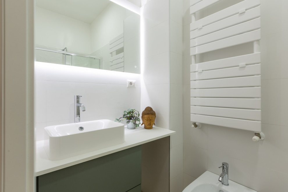 На фото: маленькая ванная комната в стиле модернизм с плоскими фасадами, зелеными фасадами, душем без бортиков, раздельным унитазом, белой плиткой, керамической плиткой, светлым паркетным полом, душевой кабиной, настольной раковиной, душем с раздвижными дверями, белой столешницей, тумбой под одну раковину и подвесной тумбой для на участке и в саду с