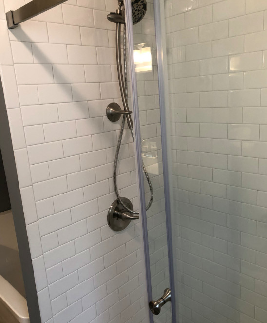 Example of a small transitional master wood-look tile floor, brown floor and single-sink sliding shower door design with furniture-like cabinets, blue cabinets, a two-piece toilet, gray walls, an integrated sink, quartz countertops, white countertops and a freestanding vanity