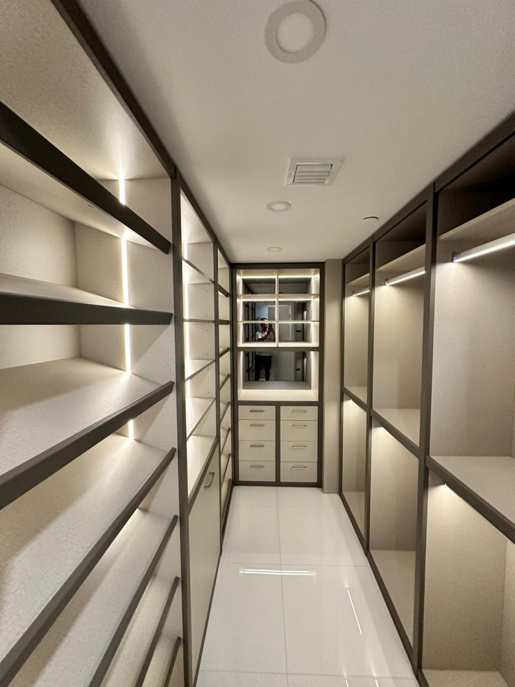 Modern inredning av ett mellanstort walk-in-closet för könsneutrala, med släta luckor, beige skåp, marmorgolv och vitt golv