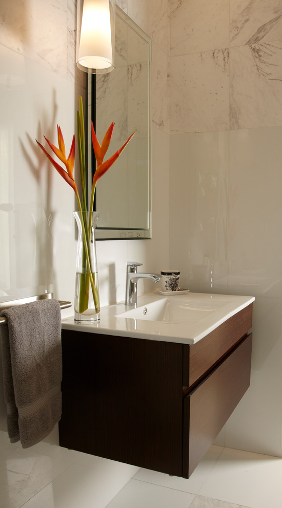Small trendy multicolored tile and marble tile marble floor and white floor bathroom photo in Miami with flat-panel cabinets, dark wood cabinets, a one-piece toilet, multicolored walls, an integrated sink and quartz countertops