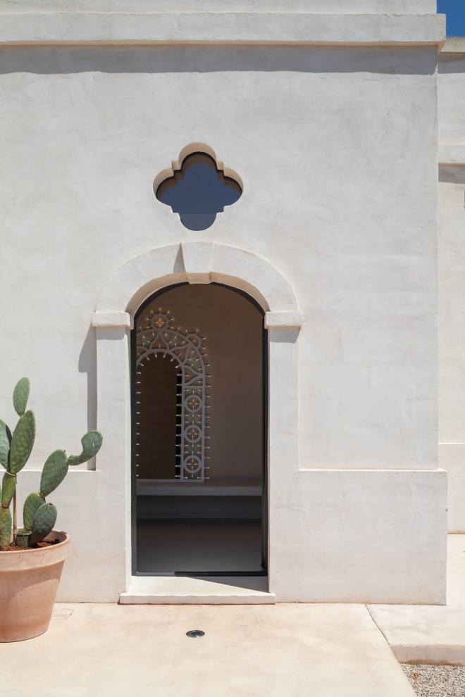 Photo of a mediterranean entrance in Other with beige walls, terrazzo flooring, a single front door, a black front door, beige floors and a drop ceiling.