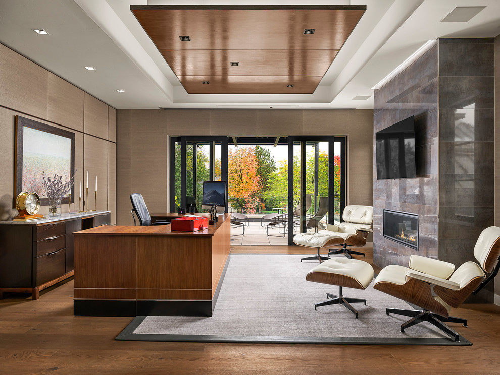 Large contemporary study room in Denver with brown walls, medium hardwood floors, a tile fireplace surround, a freestanding desk, brown floor and a ribbon fireplace.