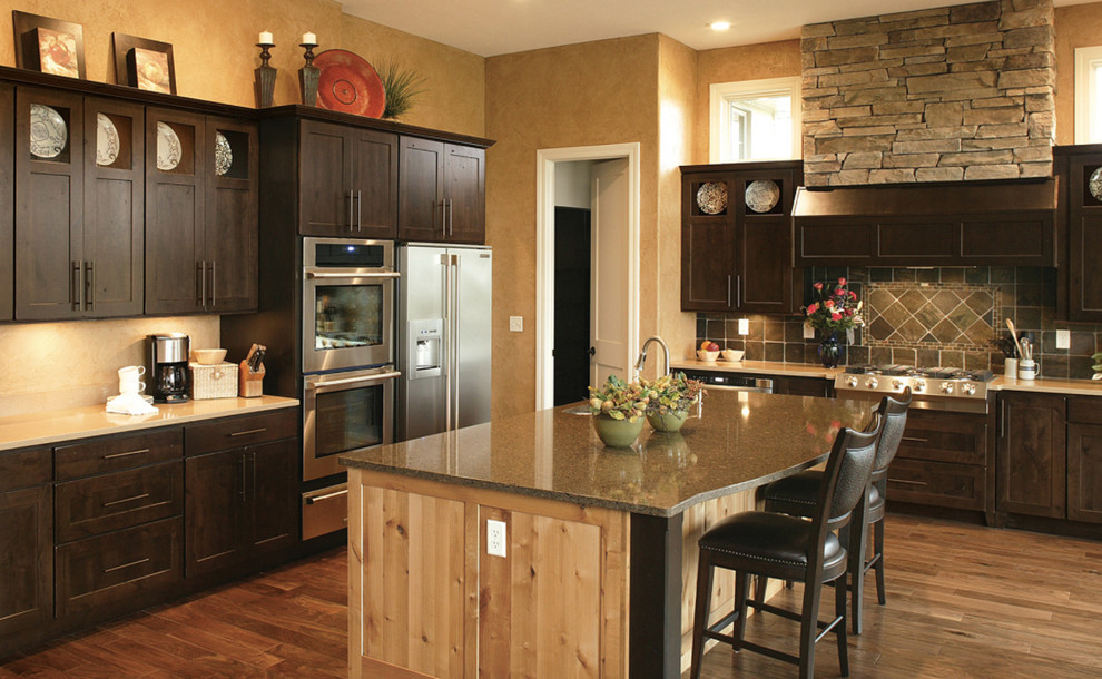 Inspiration for a large transitional l-shaped dark wood floor kitchen remodel with an undermount sink, recessed-panel cabinets, dark wood cabinets, stainless steel appliances and an island