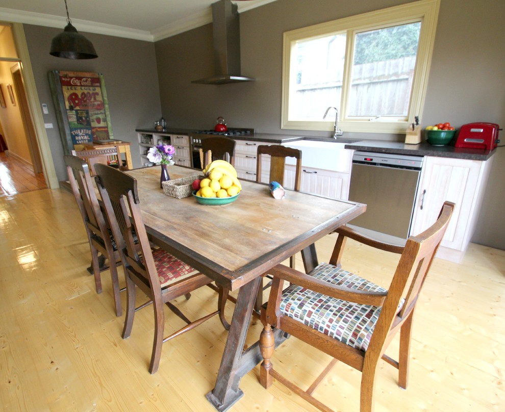 Inspiration for a small eclectic single-wall eat-in kitchen in Melbourne with a farmhouse sink, beaded inset cabinets, white cabinets, quartz benchtops, beige splashback, porcelain splashback, stainless steel appliances, light hardwood floors and no island.