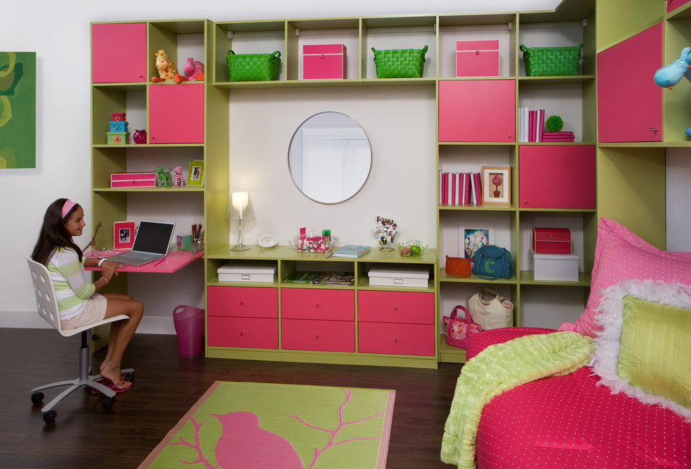 This is an example of a large transitional kids' room for girls in New York with white walls and dark hardwood floors.