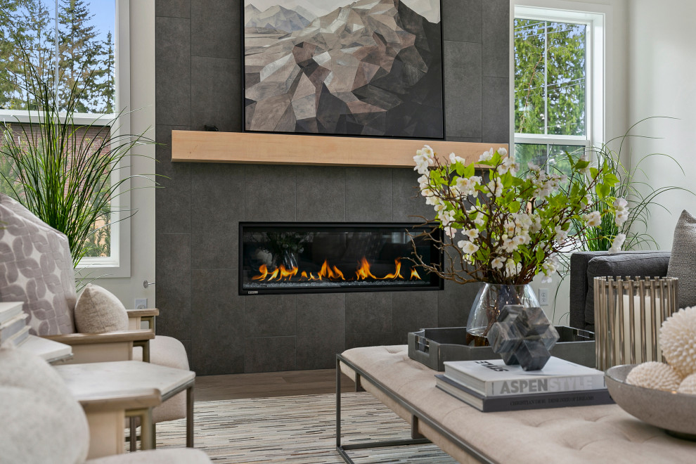 This is an example of a large country open concept living room in Seattle with white walls, light hardwood floors, a standard fireplace, a stone fireplace surround, no tv and white floor.