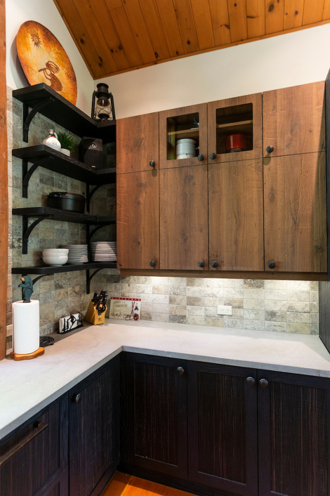 This is an example of a mid-sized country u-shaped eat-in kitchen in Montreal with a farmhouse sink, flat-panel cabinets, medium wood cabinets, concrete benchtops, grey splashback, stone tile splashback, stainless steel appliances, medium hardwood floors, with island, orange floor and grey benchtop.