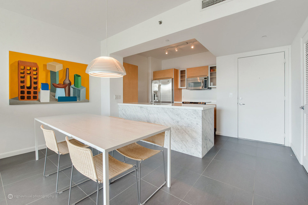 Design ideas for a small contemporary galley open plan kitchen in Miami with a single-bowl sink, flat-panel cabinets, orange cabinets, marble benchtops, white splashback, stainless steel appliances, porcelain floors and a peninsula.