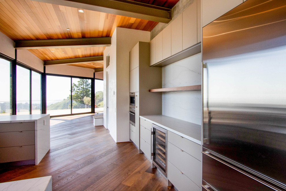 Foto de cocina industrial grande con armarios con paneles lisos, puertas de armario beige, suelo marrón, encimeras multicolor y vigas vistas