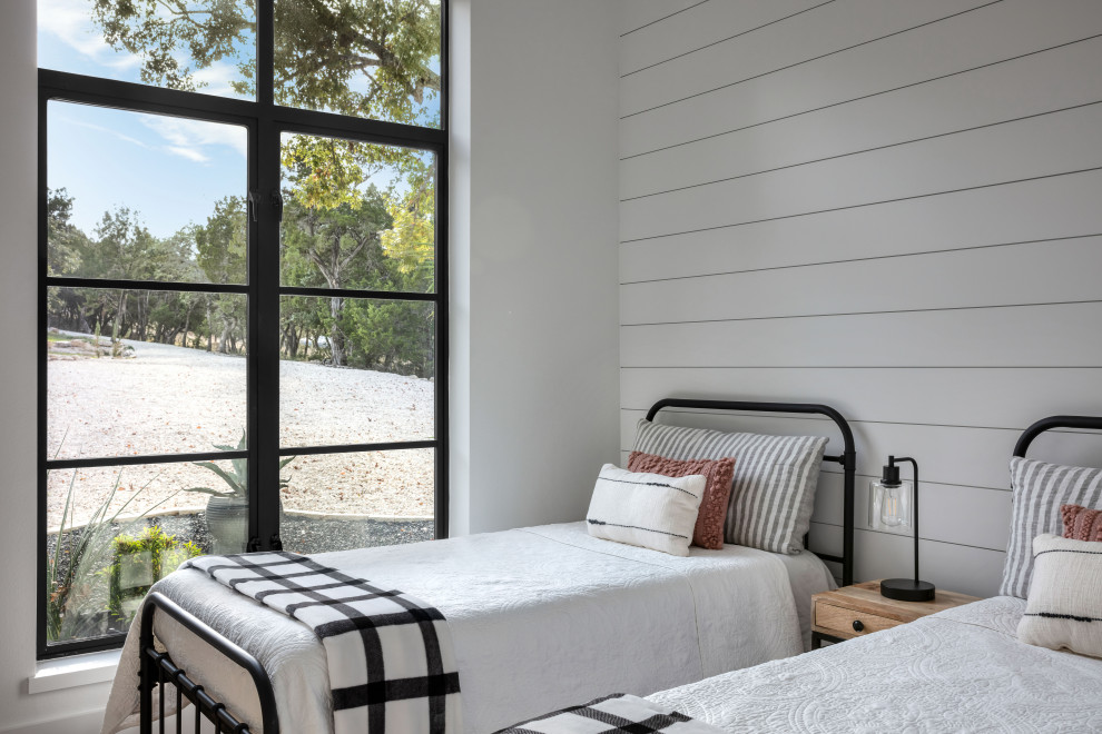На фото: маленькая гостевая спальня (комната для гостей) в стиле кантри с белыми стенами, светлым паркетным полом, коричневым полом и стенами из вагонки для на участке и в саду