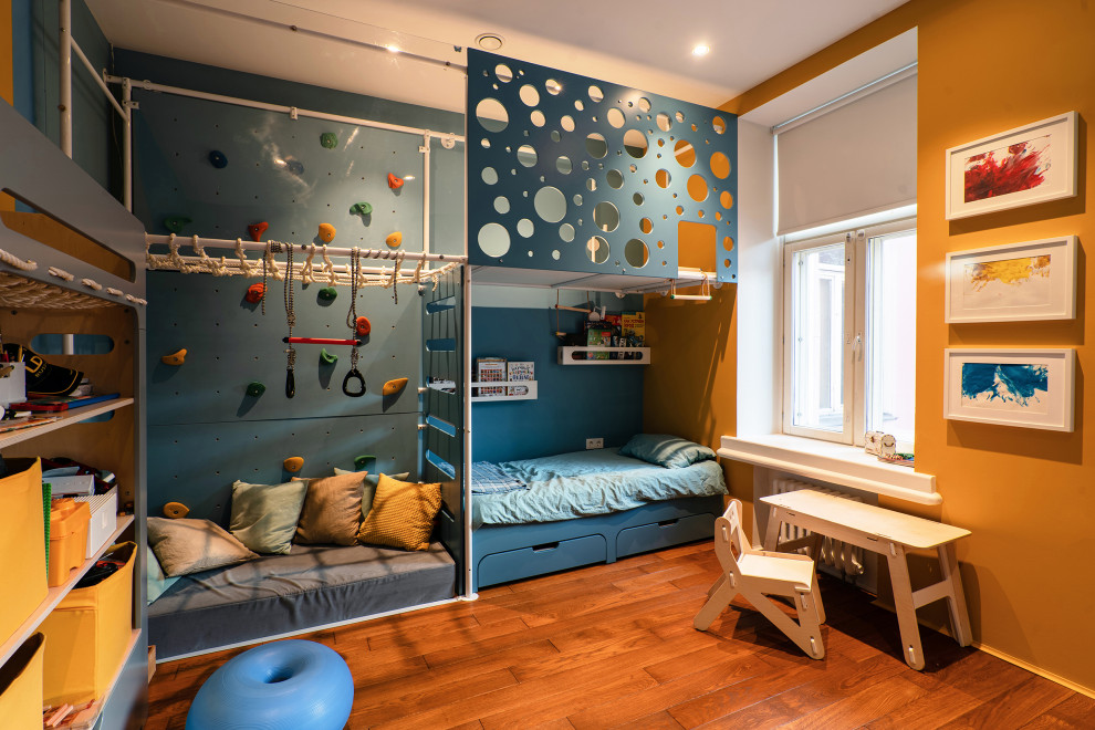 Imagen de cuarto de juegos de 1 a 3 años urbano de tamaño medio con paredes blancas, suelo de madera en tonos medios, bandeja y ladrillo