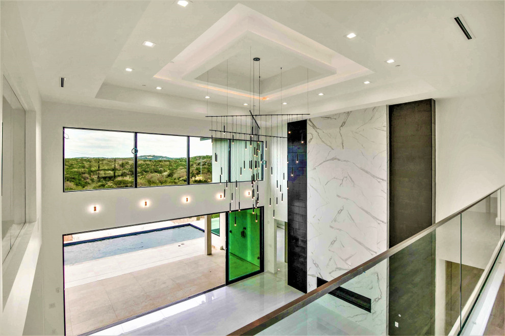 Großes, Offenes Modernes Wohnzimmer mit schwarzer Wandfarbe, Porzellan-Bodenfliesen, gefliester Kaminumrandung, TV-Wand, weißem Boden und eingelassener Decke in Austin