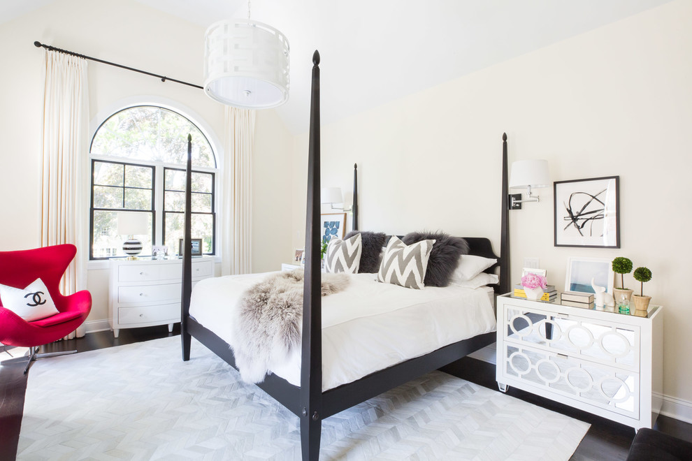 This is an example of a transitional bedroom in New York with beige walls and dark hardwood floors.