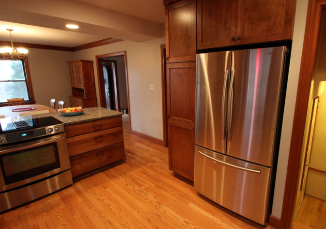Eat-in kitchen - mid-sized transitional l-shaped light wood floor eat-in kitchen idea with an undermount sink, shaker cabinets, dark wood cabinets, granite countertops, multicolored backsplash, mosaic tile backsplash, stainless steel appliances and a peninsula