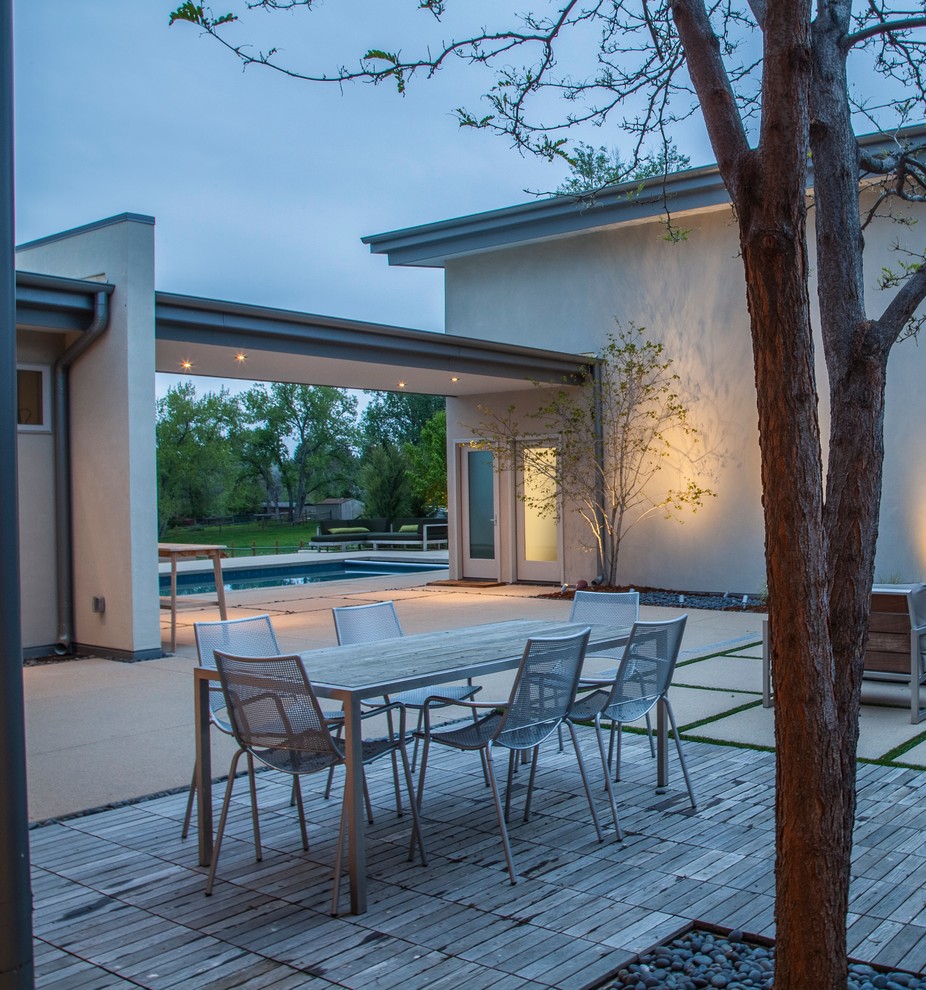 Inspiration for a large modern backyard concrete paver patio remodel in Denver with no cover