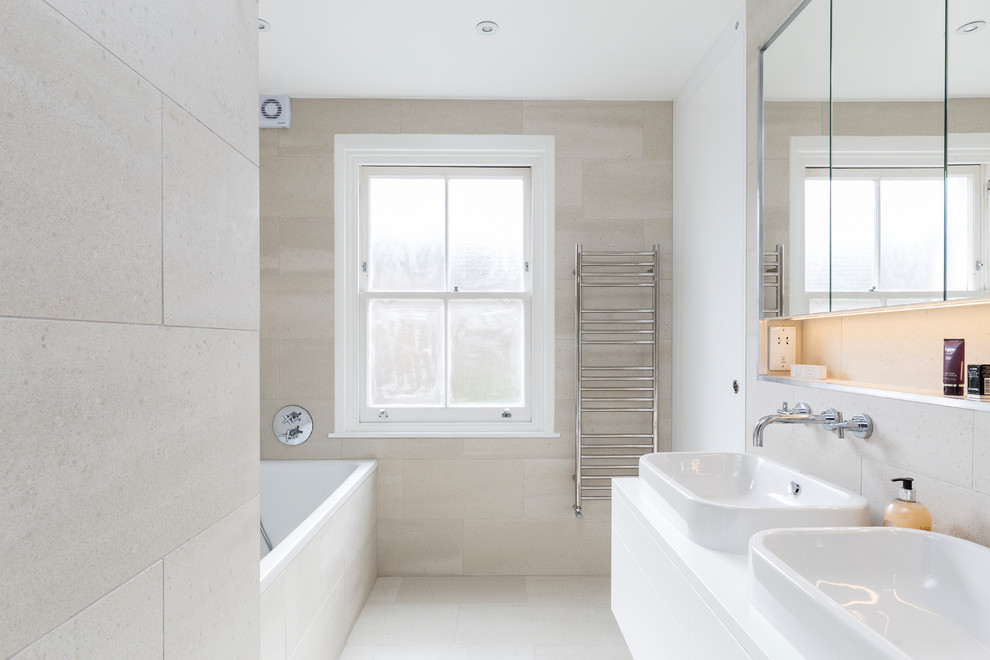 Inspiration for a small contemporary kids bathroom in London with flat-panel cabinets, white cabinets, a drop-in tub, a curbless shower, a wall-mount toilet, beige tile, cement tile, beige walls, cement tiles, a console sink, quartzite benchtops, beige floor and a hinged shower door.