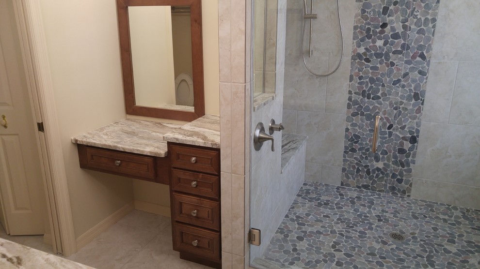 Design ideas for a mid-sized contemporary master bathroom in Miami with an undermount sink, recessed-panel cabinets, medium wood cabinets, granite benchtops, a corner shower, gray tile, pebble tile, multi-coloured walls and porcelain floors.