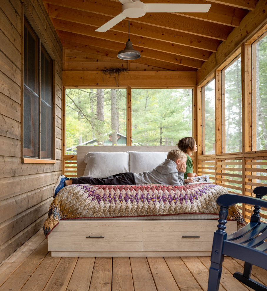 Réalisation d'un porche d'entrée de maison chalet avec une moustiquaire, une terrasse en bois, une extension de toiture et un garde-corps en bois.