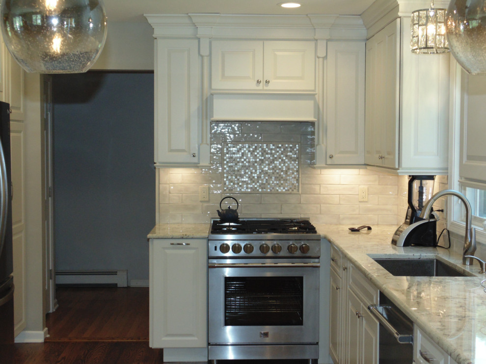 Mid-sized transitional u-shaped medium tone wood floor and brown floor eat-in kitchen photo with an undermount sink, raised-panel cabinets, white cabinets, granite countertops, white backsplash, subway tile backsplash, stainless steel appliances, no island and gray countertops