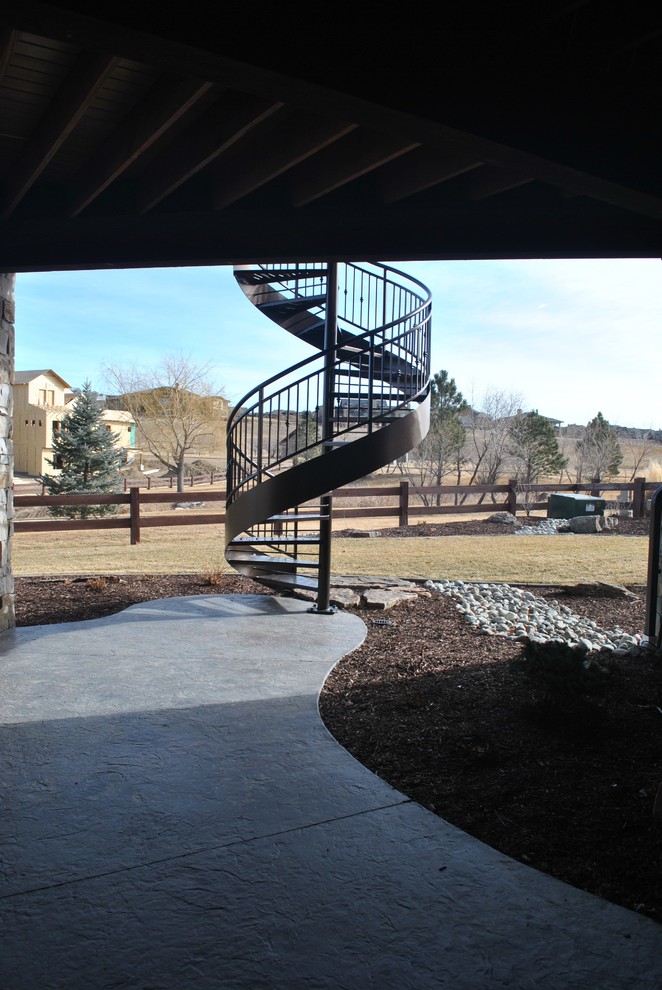 Design ideas for a mid-sized traditional metal spiral staircase in Denver with open risers and metal railing.