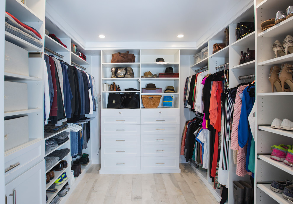 This is an example of a mid-sized transitional walk-in wardrobe in Los Angeles with shaker cabinets, white cabinets and terra-cotta floors.
