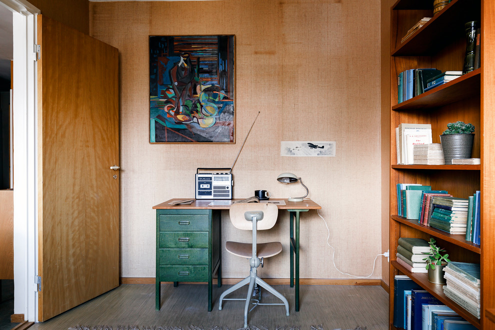 Midcentury home office in Stockholm with beige walls, linoleum floors, a freestanding desk and grey floor.