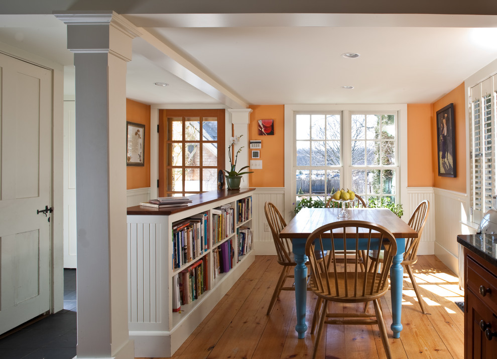 Mid-sized traditional dining room in Boston with orange walls.